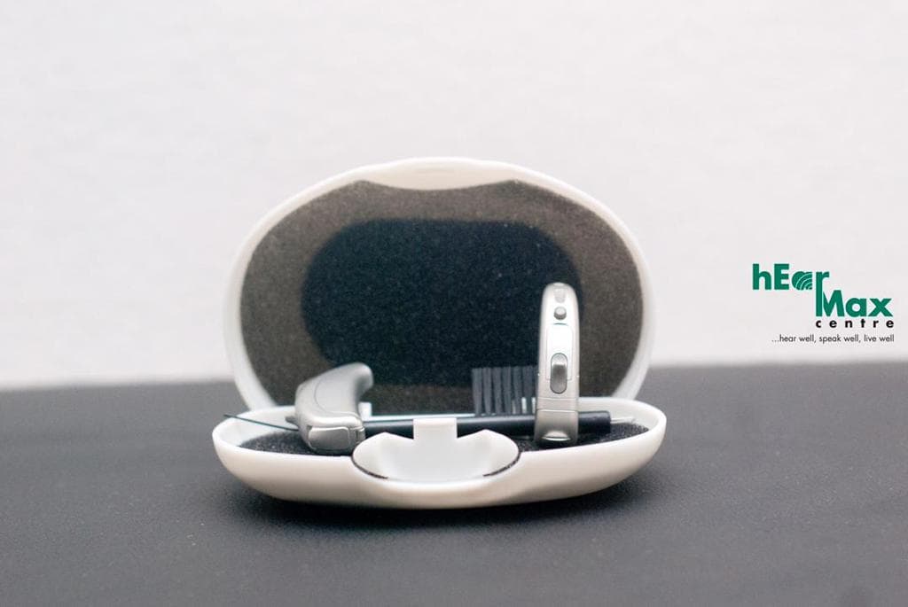 Behind-the-ear hearing aid in its protective case